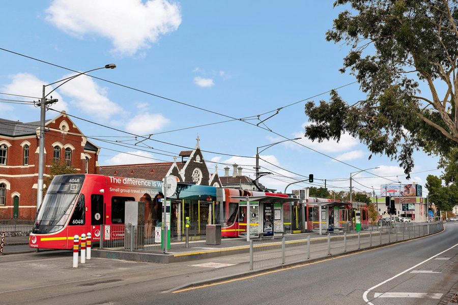 Tram stop beside heritage brick buildings in Carlton
